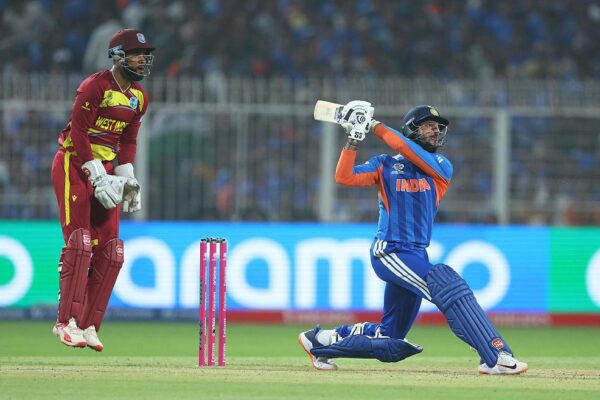 Packed cricket stadium during a T20 World Cup match with bright floodlights and intense crowd atmosphere.