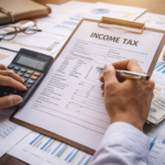 Person calculating income tax with documents and financial charts