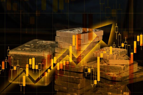 Gold and silver bars placed over a falling financial market chart.