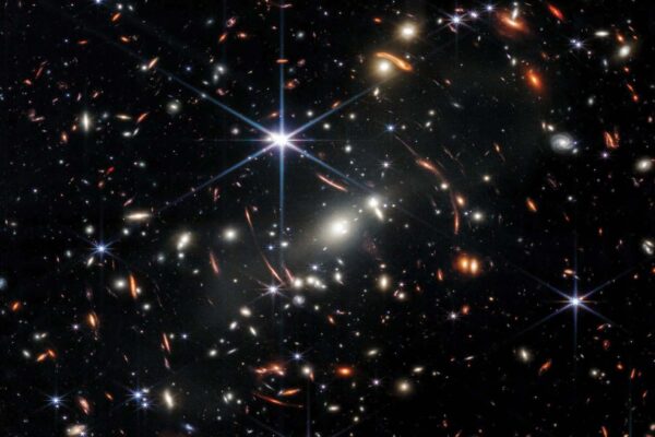 Deep space galaxy cluster captured by the James Webb Space Telescope showing ancient galaxies in infrared light.